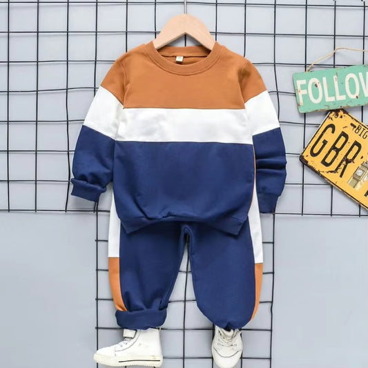 Colorblock kids tracksuit set in brown, white, and navy on display, featuring a cozy sweatshirt and joggers. 795