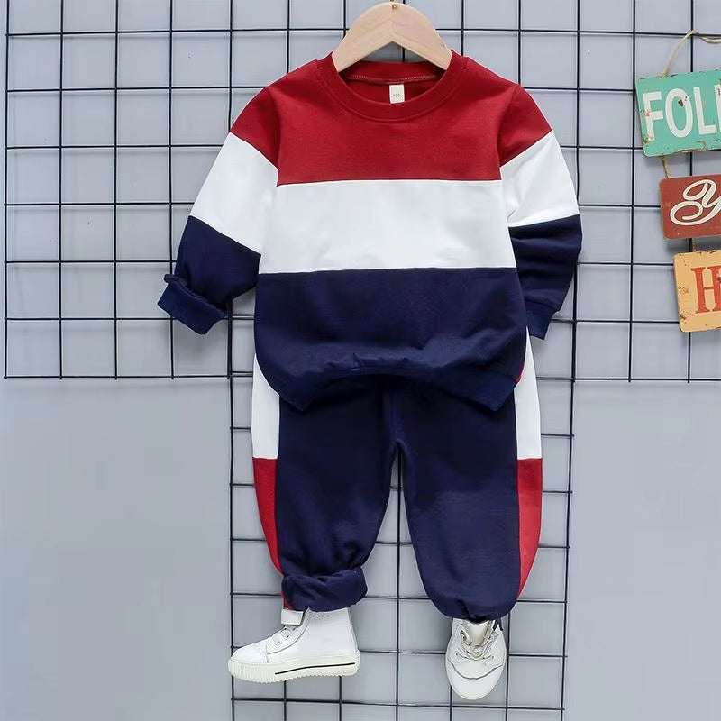 Colorblock kids tracksuit set in red, white, and navy featuring a crewneck sweatshirt and jogger pants.