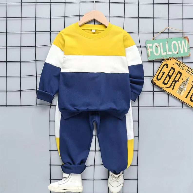 Vibrant colorblock kids tracksuit set in navy, yellow, and white, featuring a cozy pullover and joggers, perfect for play and lounging.